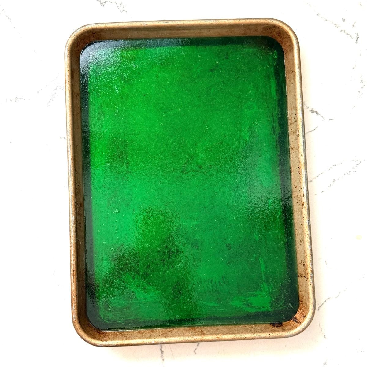 Green pandan jelly in a baking dish for homemade buko pandan salad