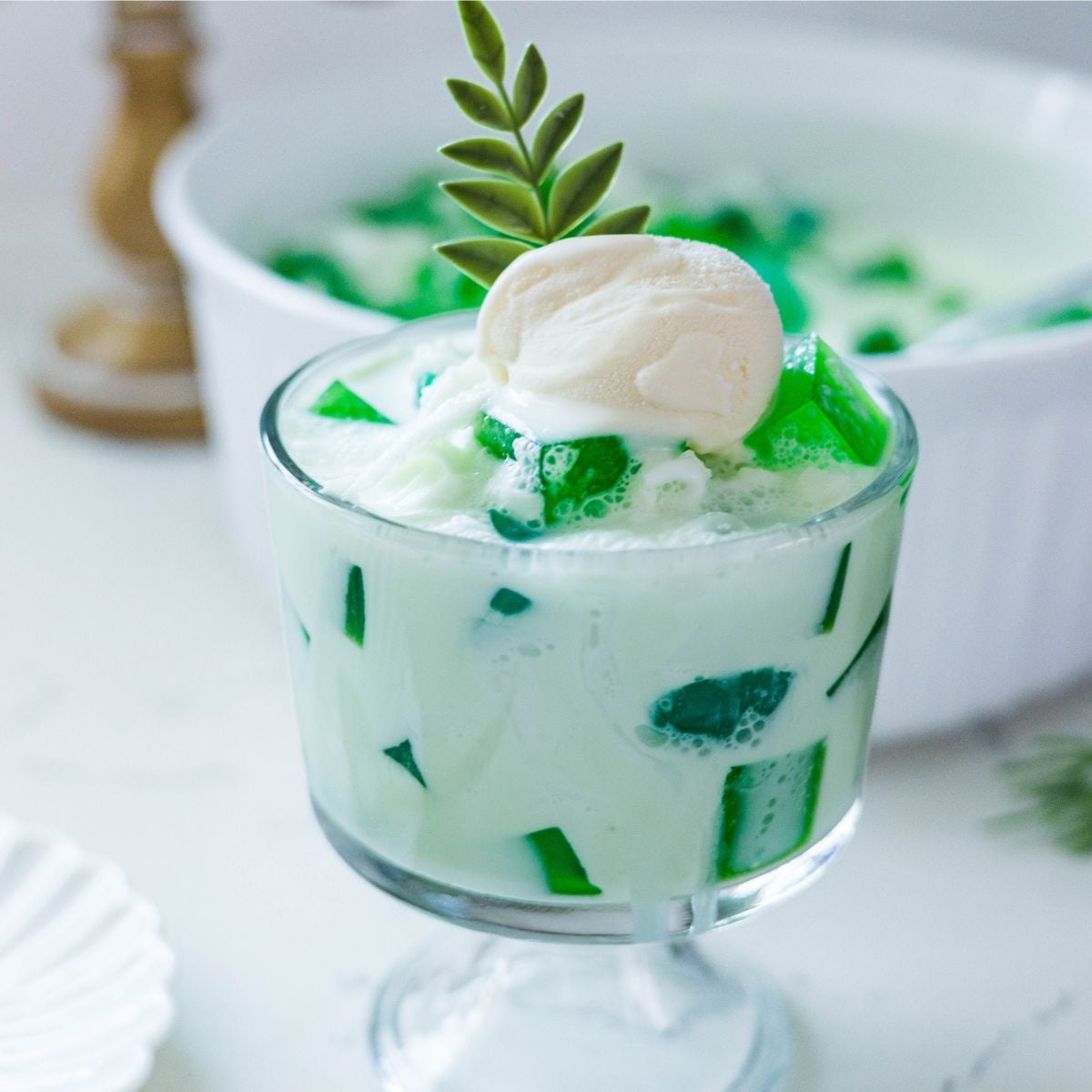 Creamy buko pandan salad served in a glass with pandan jelly and coconut