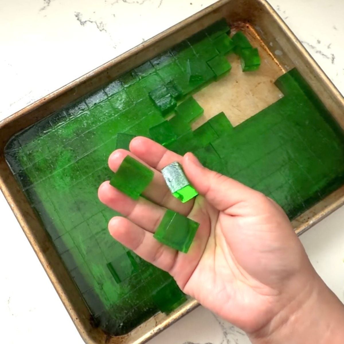 Cutting green pandan jelly into cubes for buko pandan salad