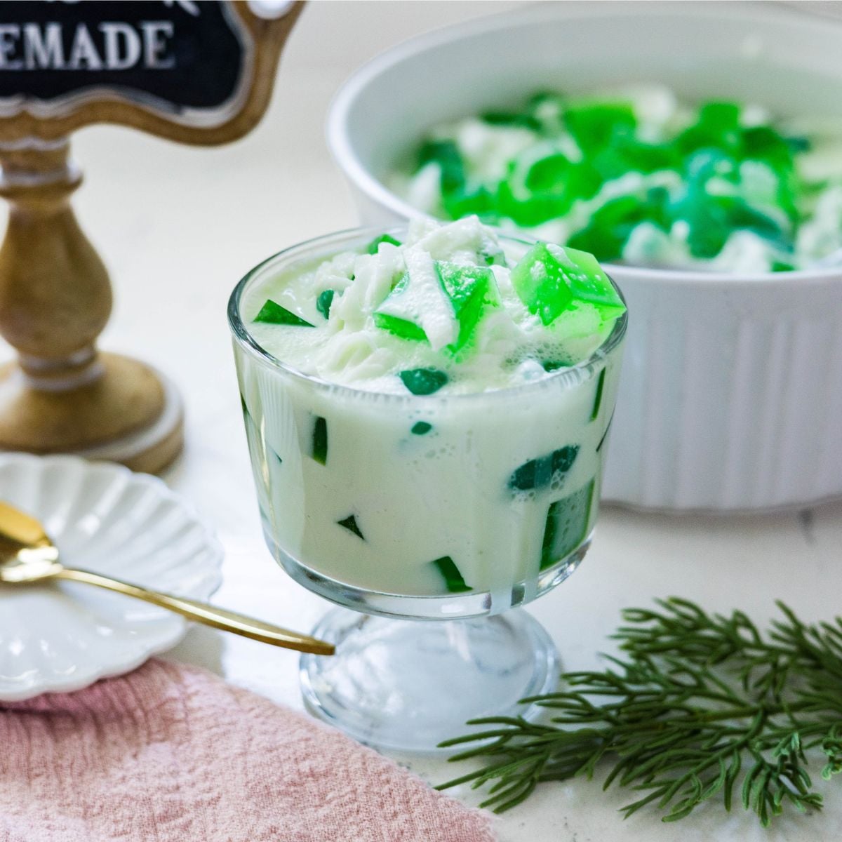 Filipino buko pandan salad served in a glass with green pandan jelly and coconut
