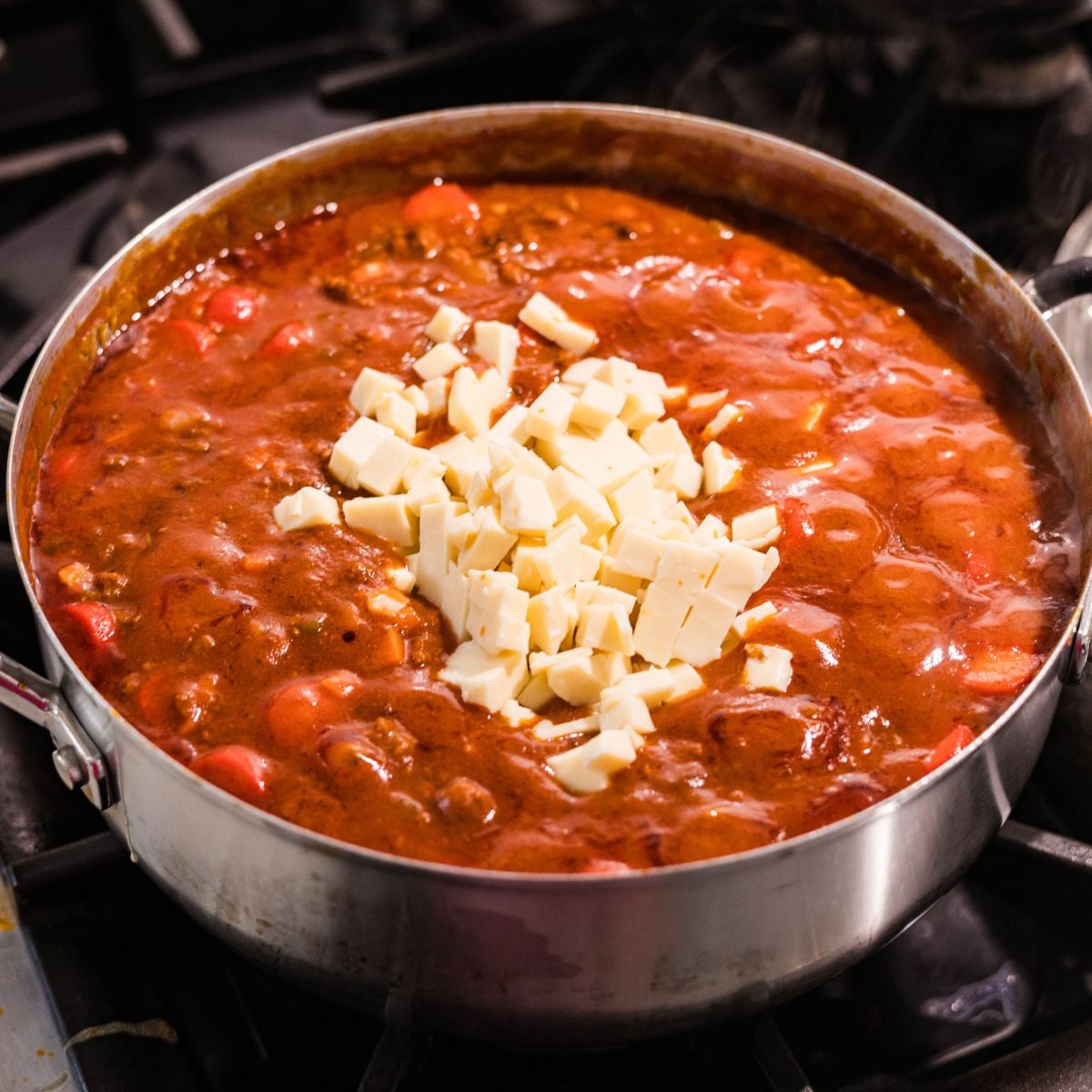 Cheese added to Filipino spaghetti sauce while cooking