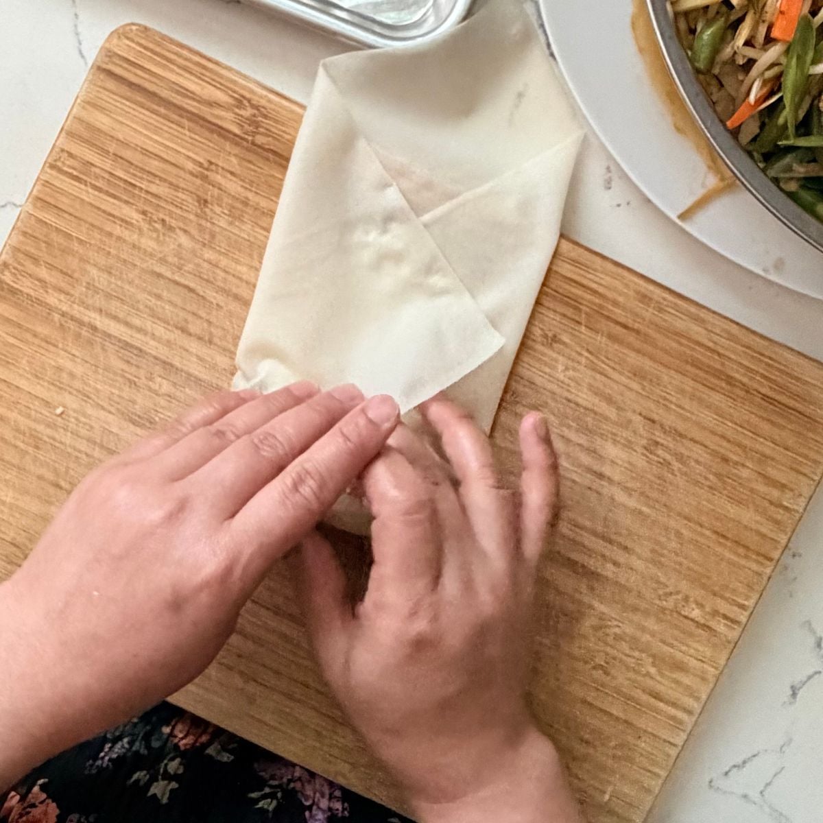 Rolling the filled wrapper to make lumpiang gulay