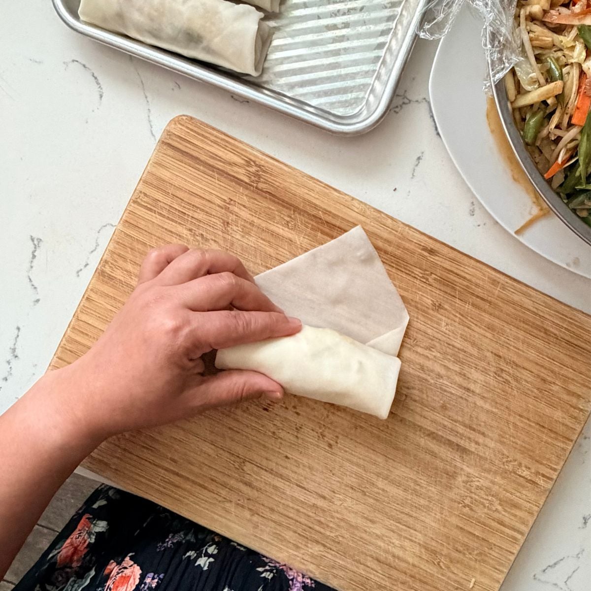 Folding a lumpiang gulay wrapper over the vegetable filling