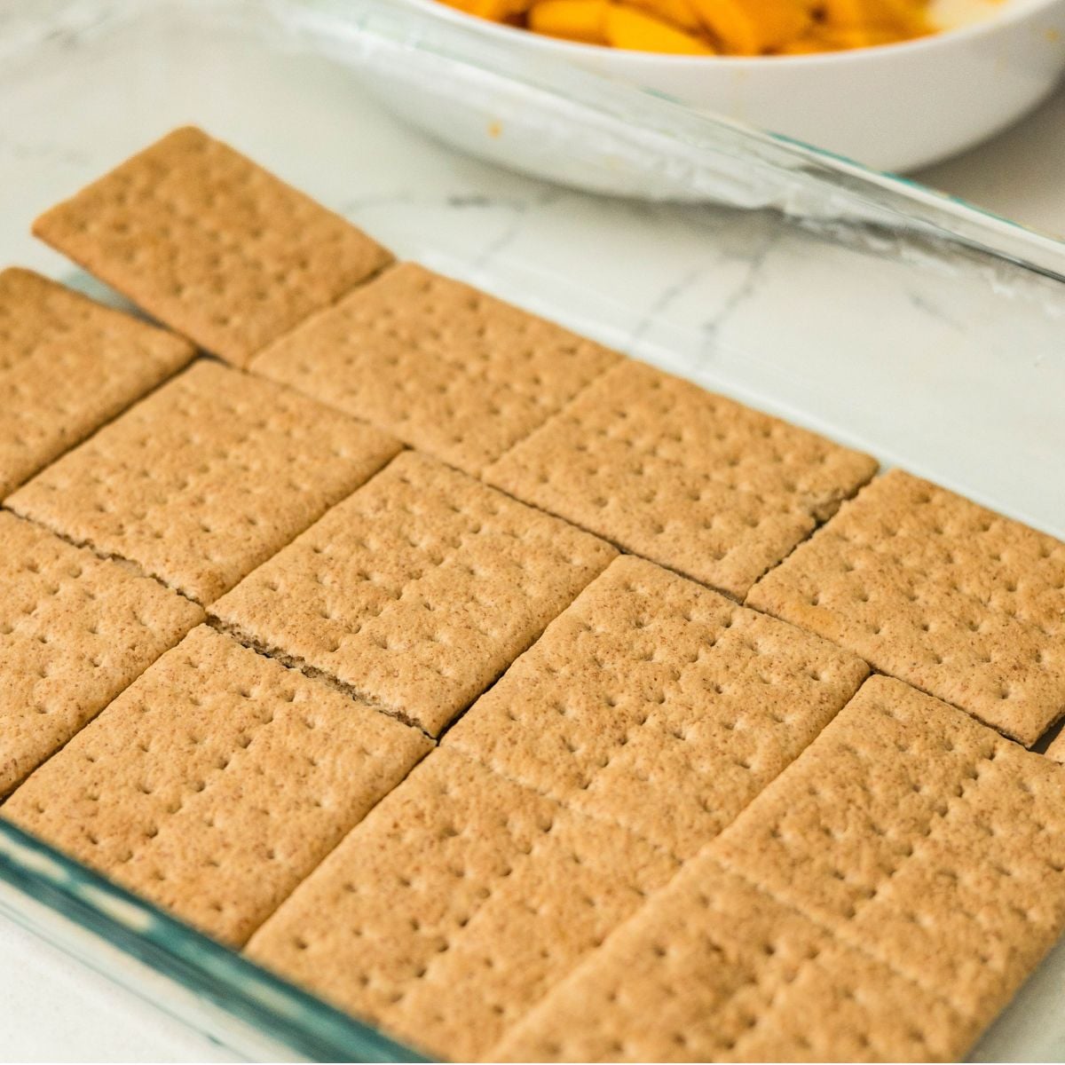 Graham crackers arranged as the base layer for mango float