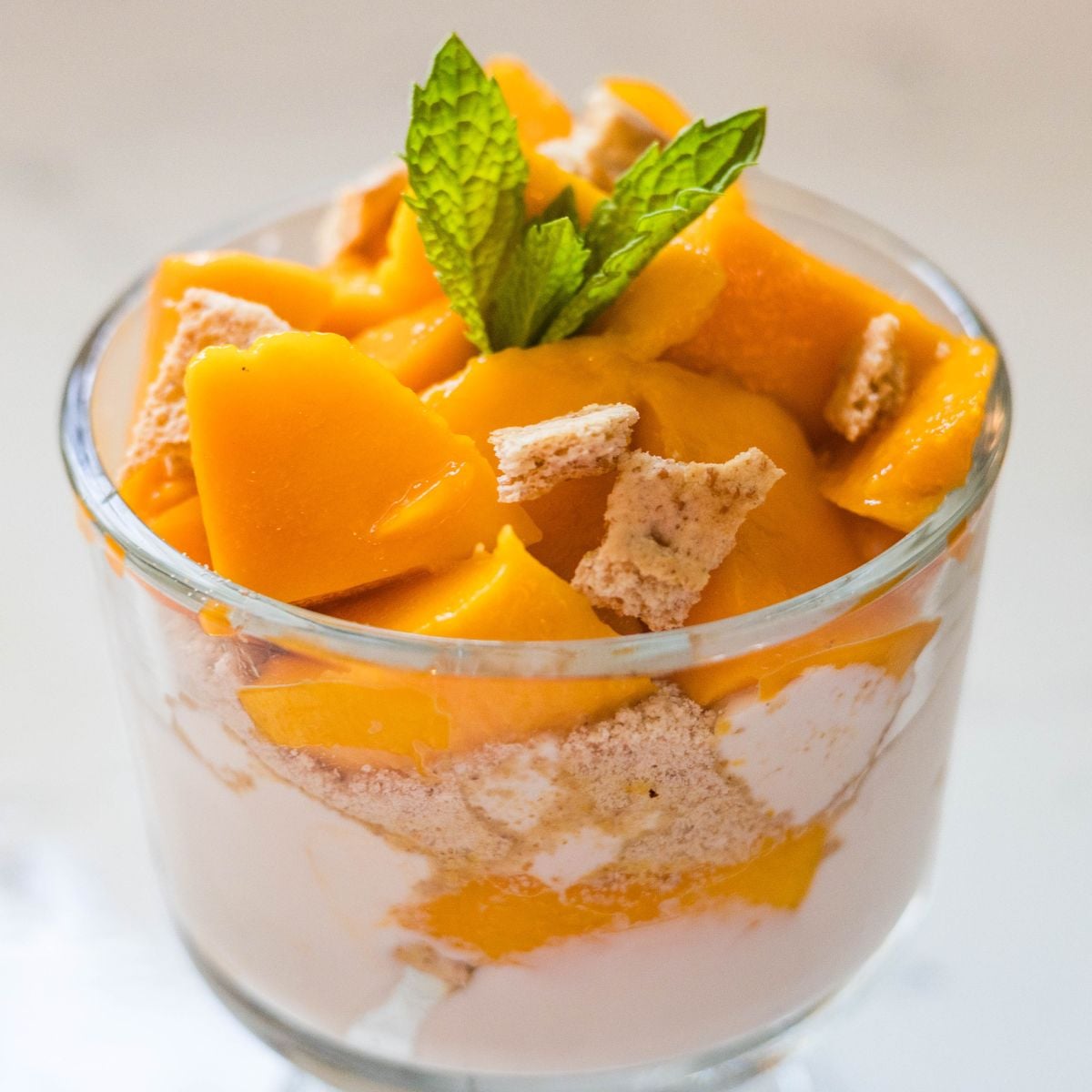 Mango graham float served in a glass dessert cup