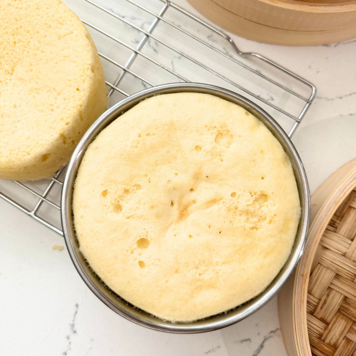 Freshly steamed yema cake layer cooling on a wire rack.