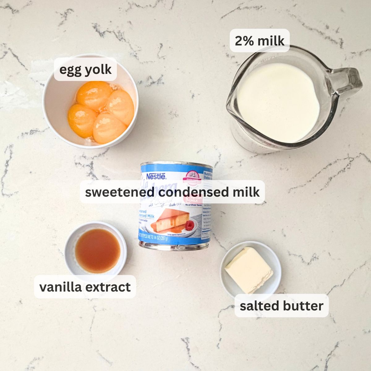 Overhead view of yema frosting ingredients: egg yolks, sweetened condensed milk, 2% milk, and vanilla.