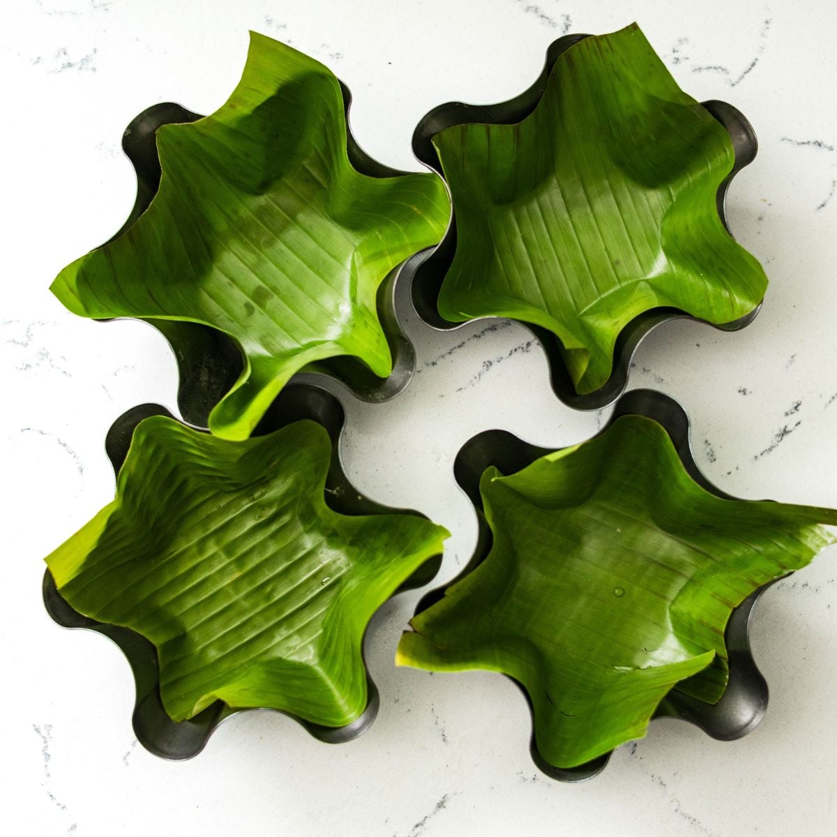 Taco salad bowl molds lined with fresh banana leaves for bibingka.