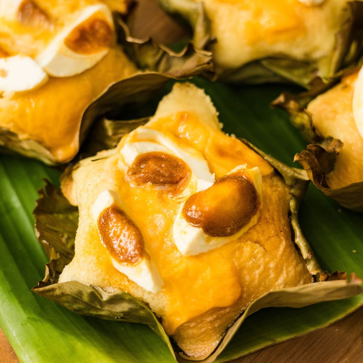 Filipino bibingka served on a banana leaf with salted egg and cheese
