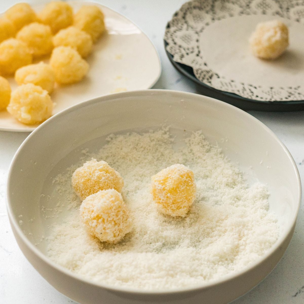 Macapuno balls being rolled in desiccated coconut for an even coating