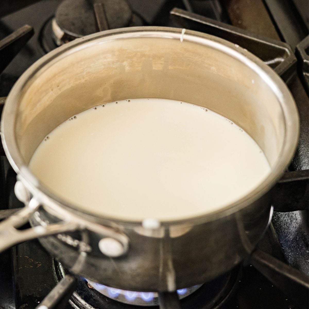 Creamy coconut milk topping cooking in a saucepan for inutak