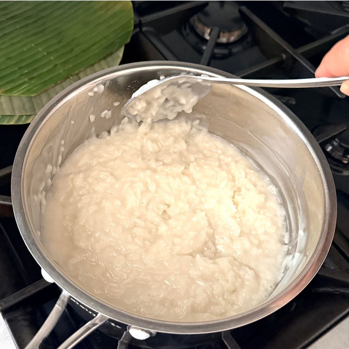 Mixing sweet rice into coconut milk for suman malagkit