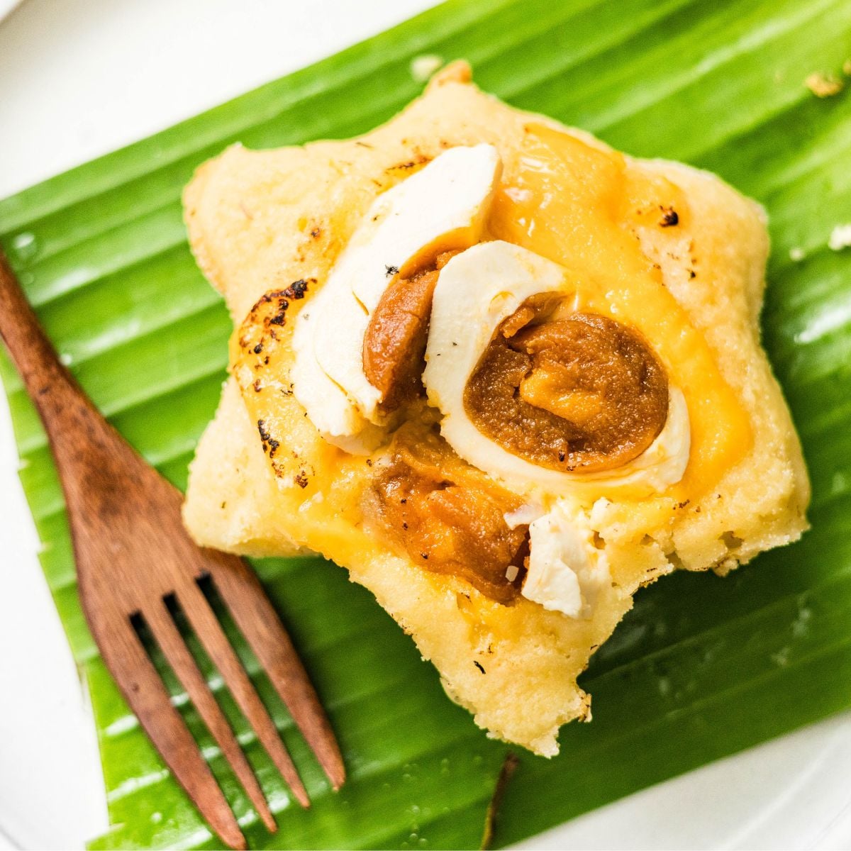 Easy Filipino bibingka with salted egg and cheese on banana leaf