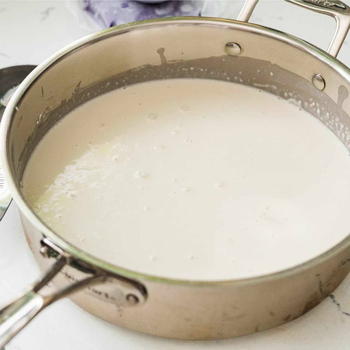 Coconut milk and rice flour mixture cooking in a saucepan for inutak