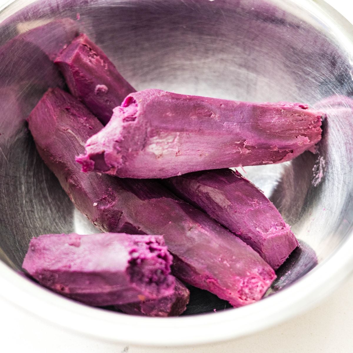 Peeled purple sweet potatoes in a bowl