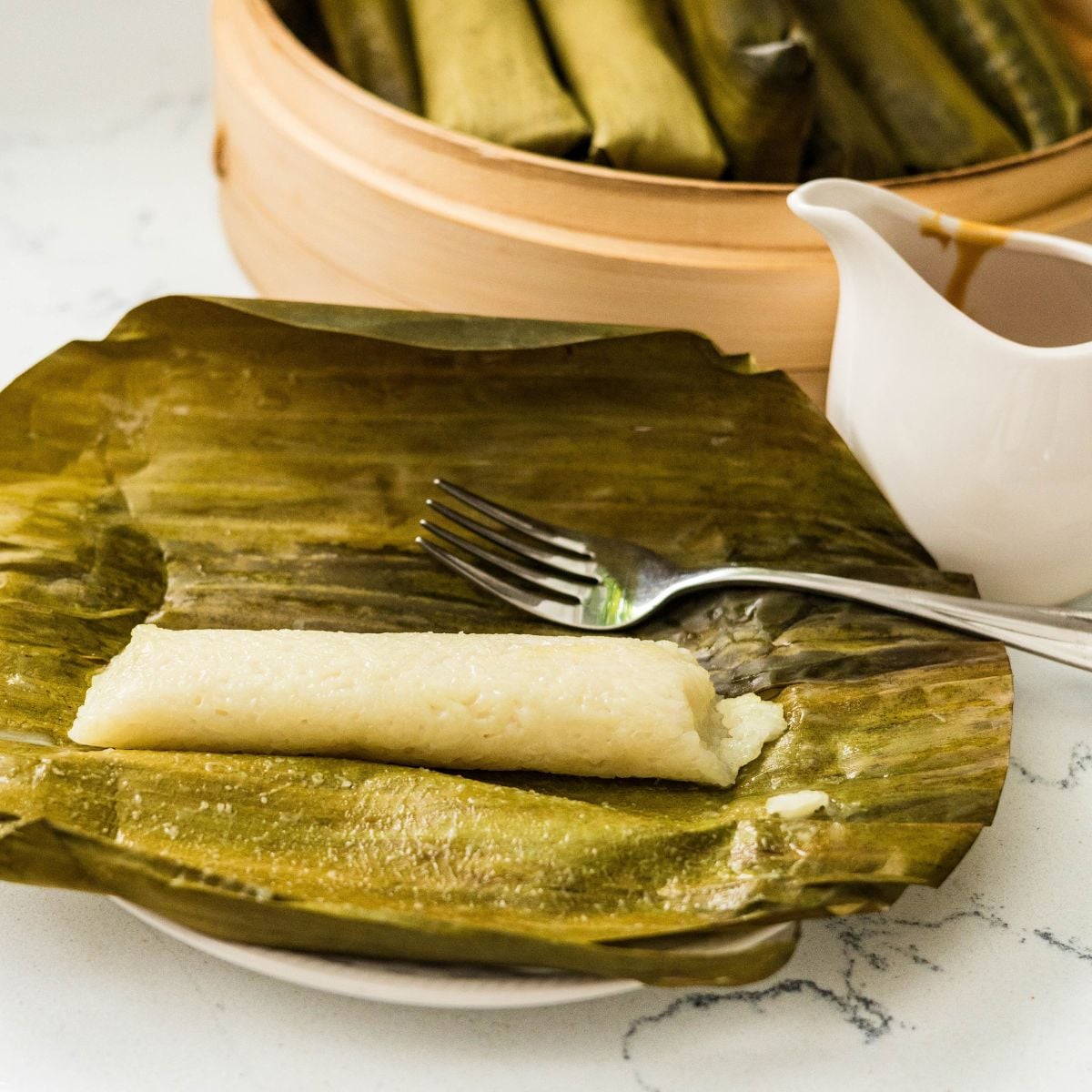 Suman malagkit served on banana leaf with coconut caramel sauce