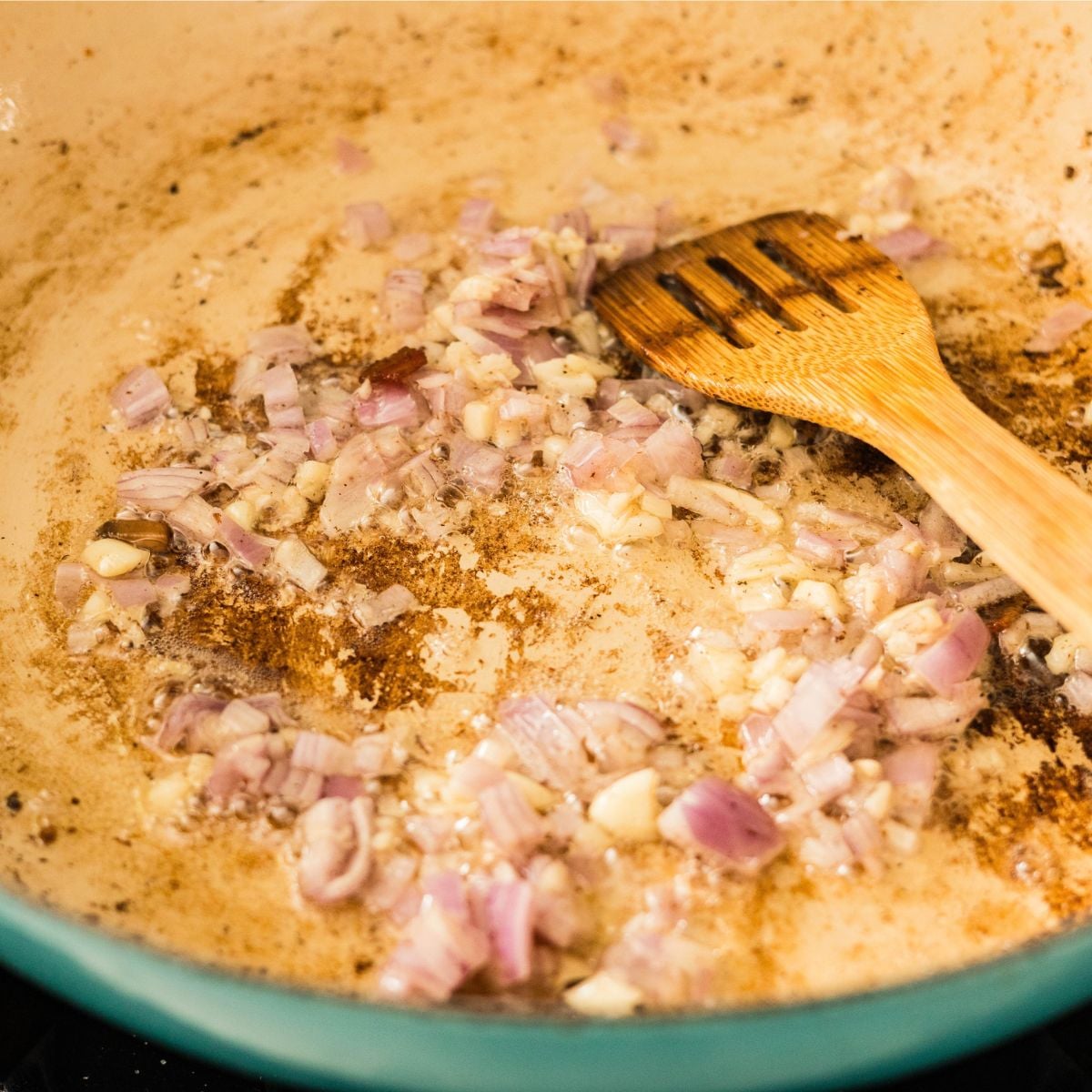 Chopped onion and garlic sautéing in a pan for carbonara