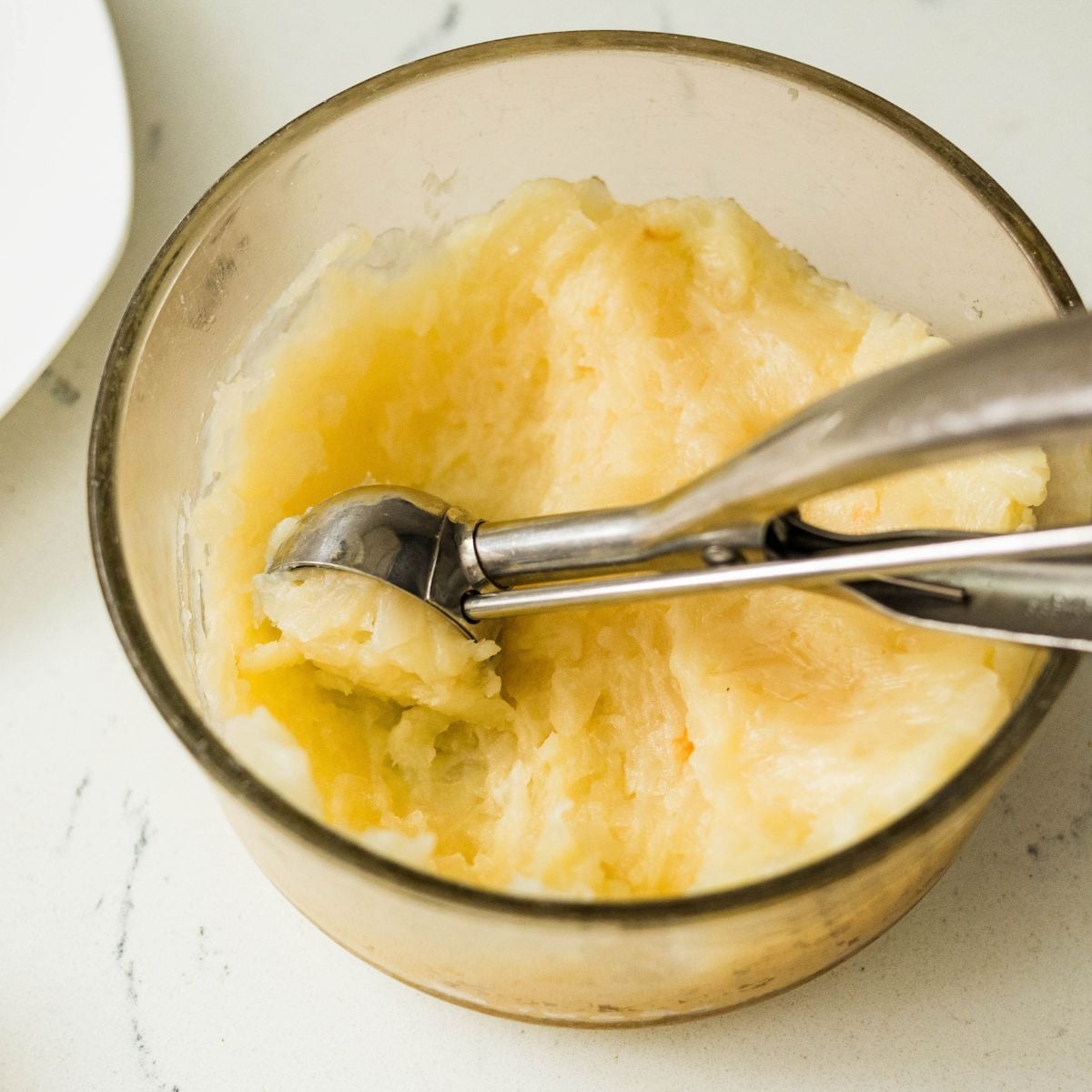 Scooping cooled macapuno mixture into portions for rolling into balls
